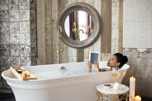 Woman in bath holding book