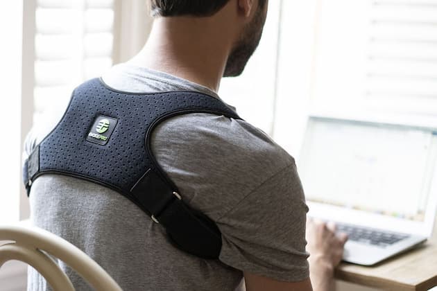 man wearing a upper back brace while working on the computer