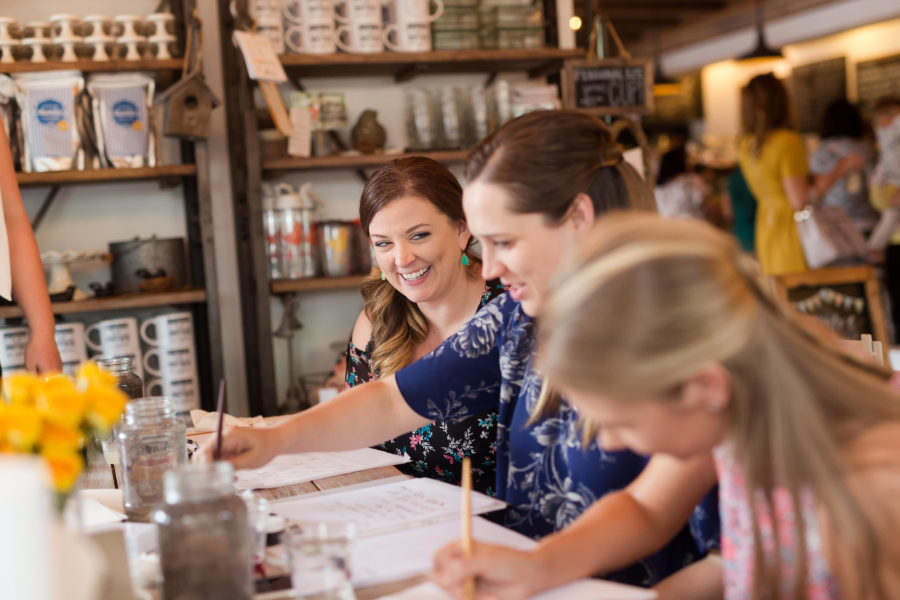 three women at a calligraphy workshop