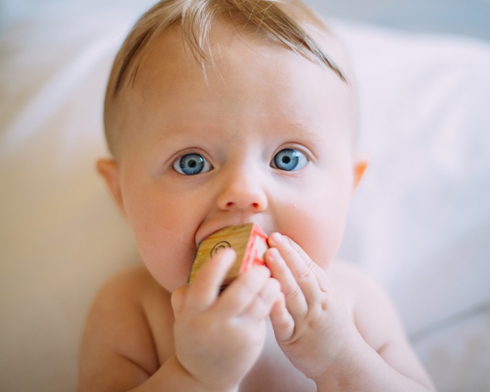 picture of a baby with a toy in its mouth