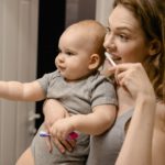 picture of a baby in the hands of a woman washing teeth