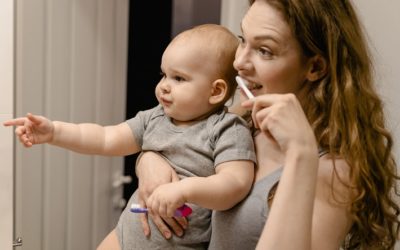 picture of a baby in the hands of a woman washing teeth