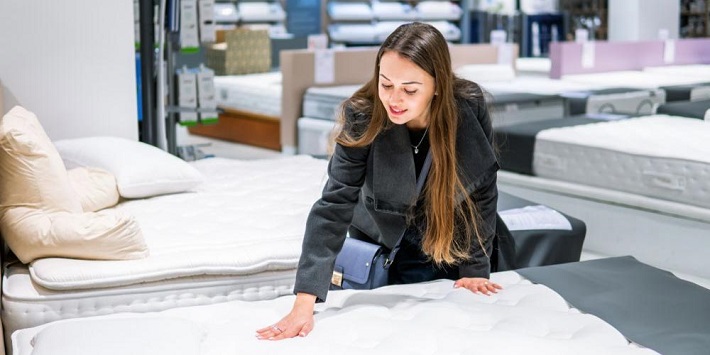 woman looking at mattresses for sale at store