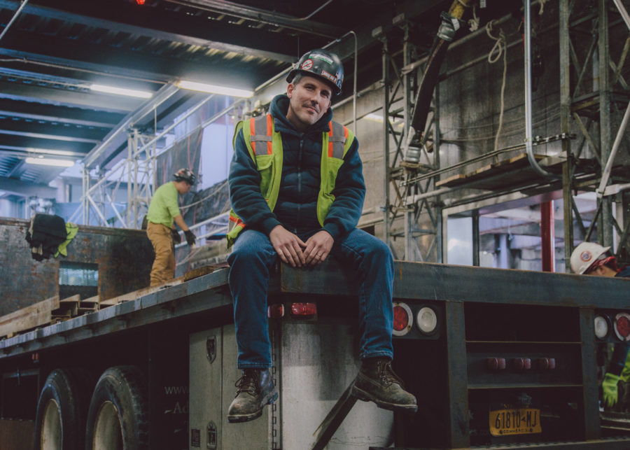 construction worker wearing a workwear and sitting on a truck trailer