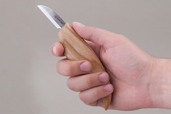 Person holding in hand wood carving bench knife