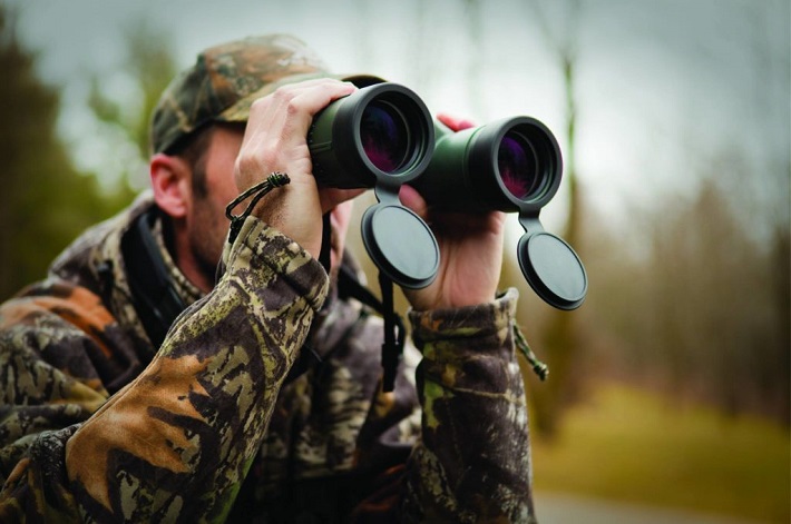 Close-up of hunter looking through binoculars