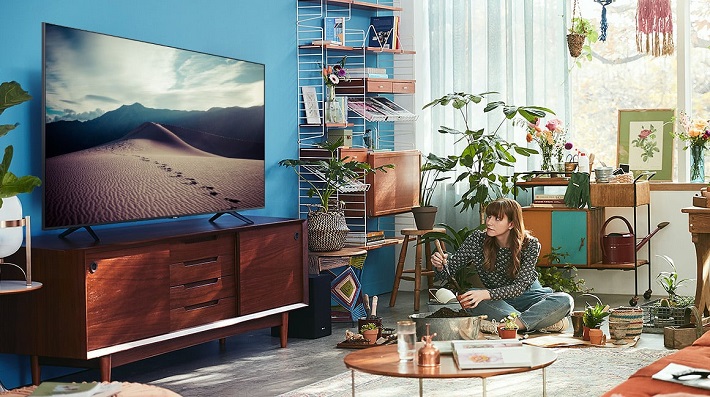 picture of a woman in a living room watching a smart tv 