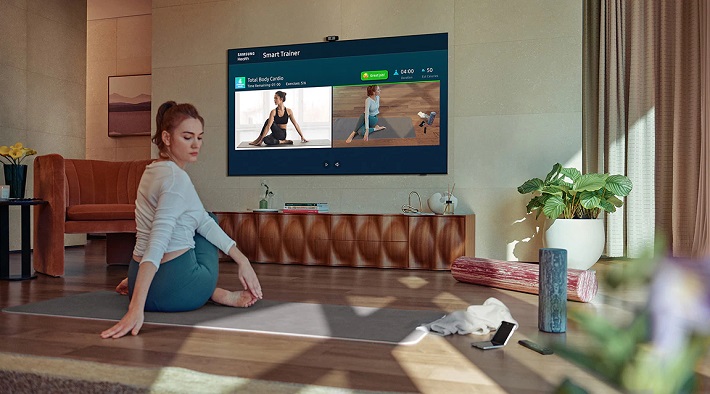 picture of a woman practicing yoga with instruction from a smart tv