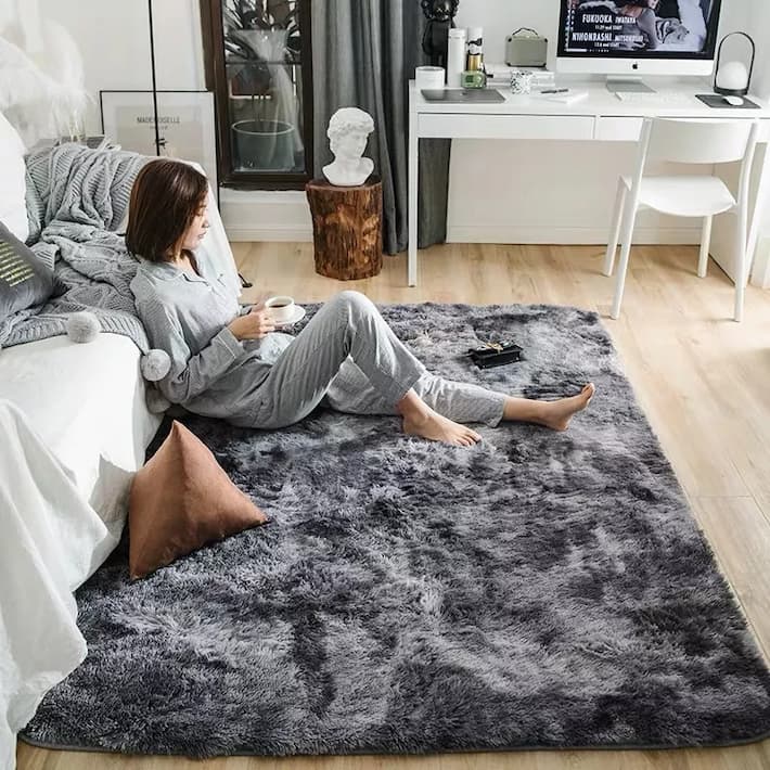 woman sitting on a grey soft plush carpet