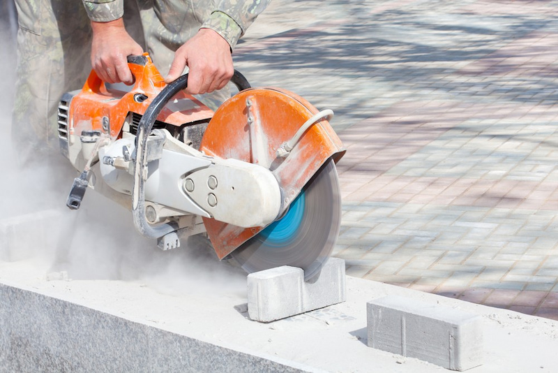 Man working with gas-powered concrete saw