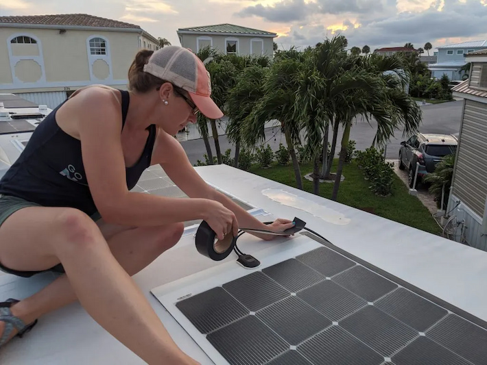 woman-install-flexible-solar-panels-on-RV