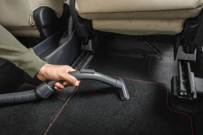 vacuuming the car floor mats