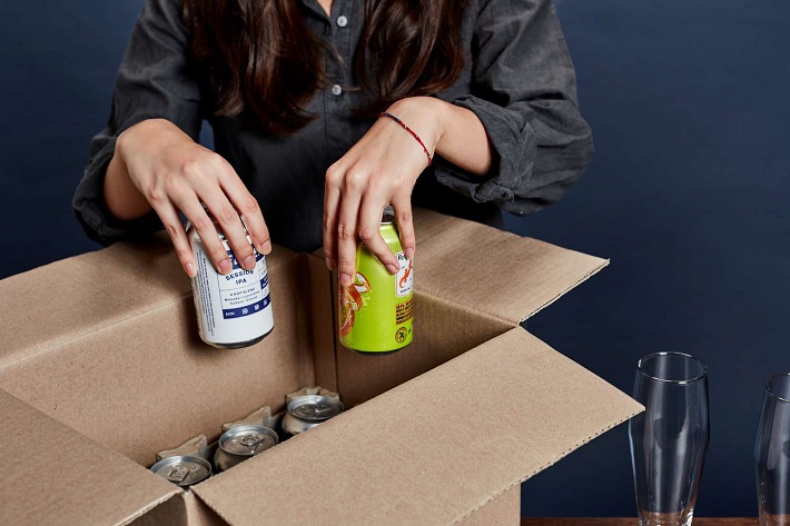 a woman takes out beers from a box