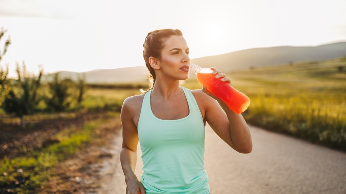 woman drinking electrolyte drink